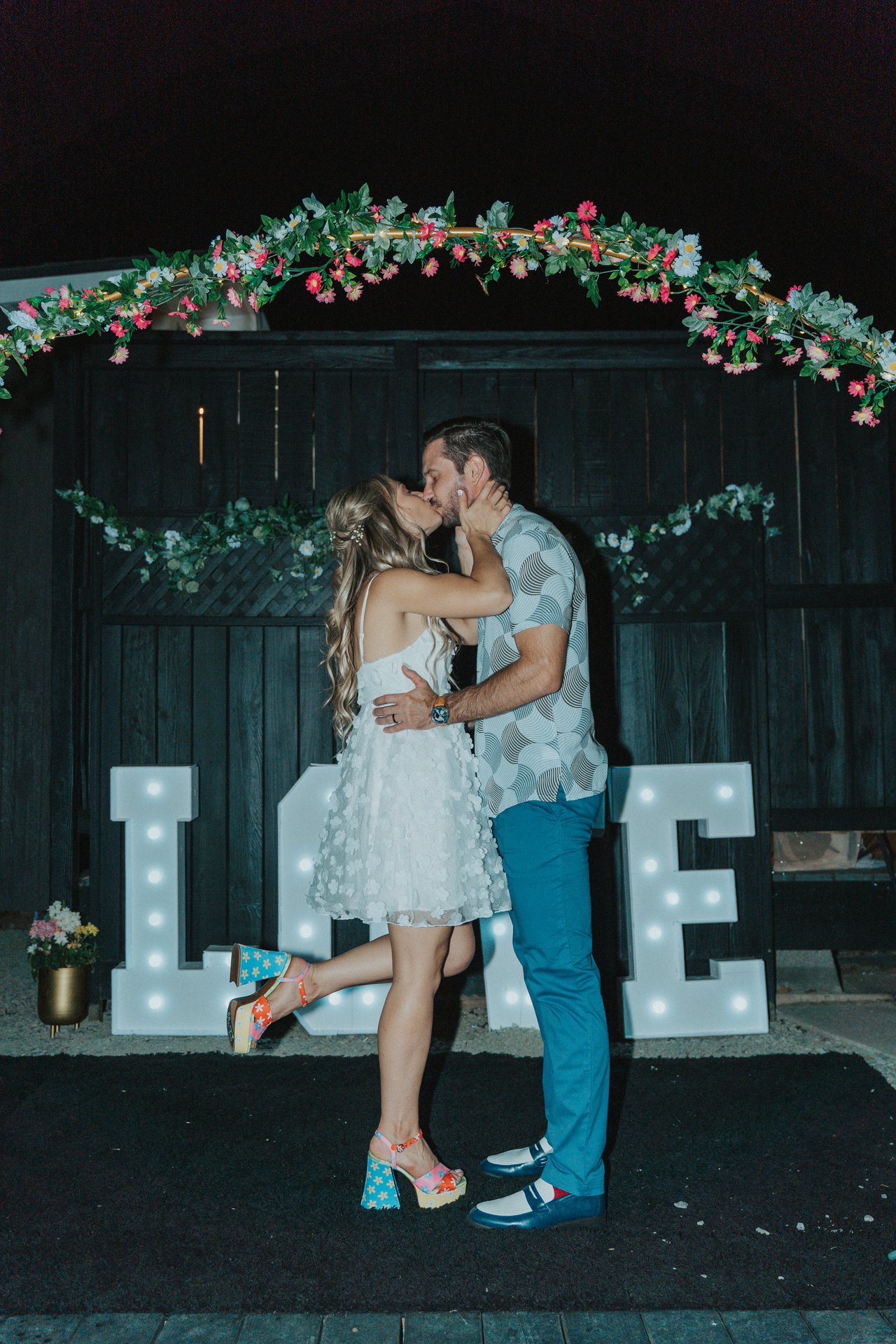Lexy and Jeremy kiss by the LOVE marquee letters