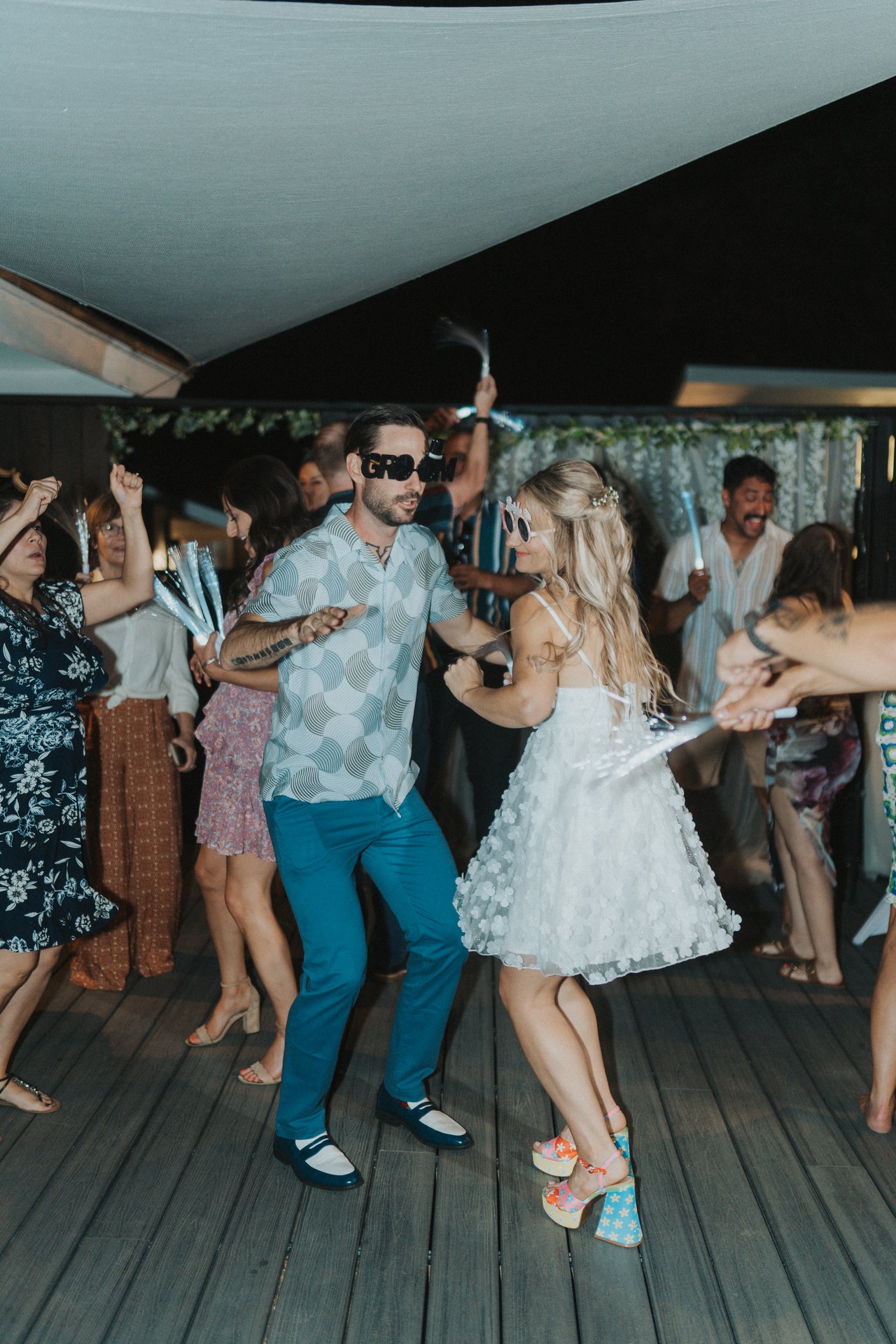 Dancing under the shade sail in novelty sunglasses