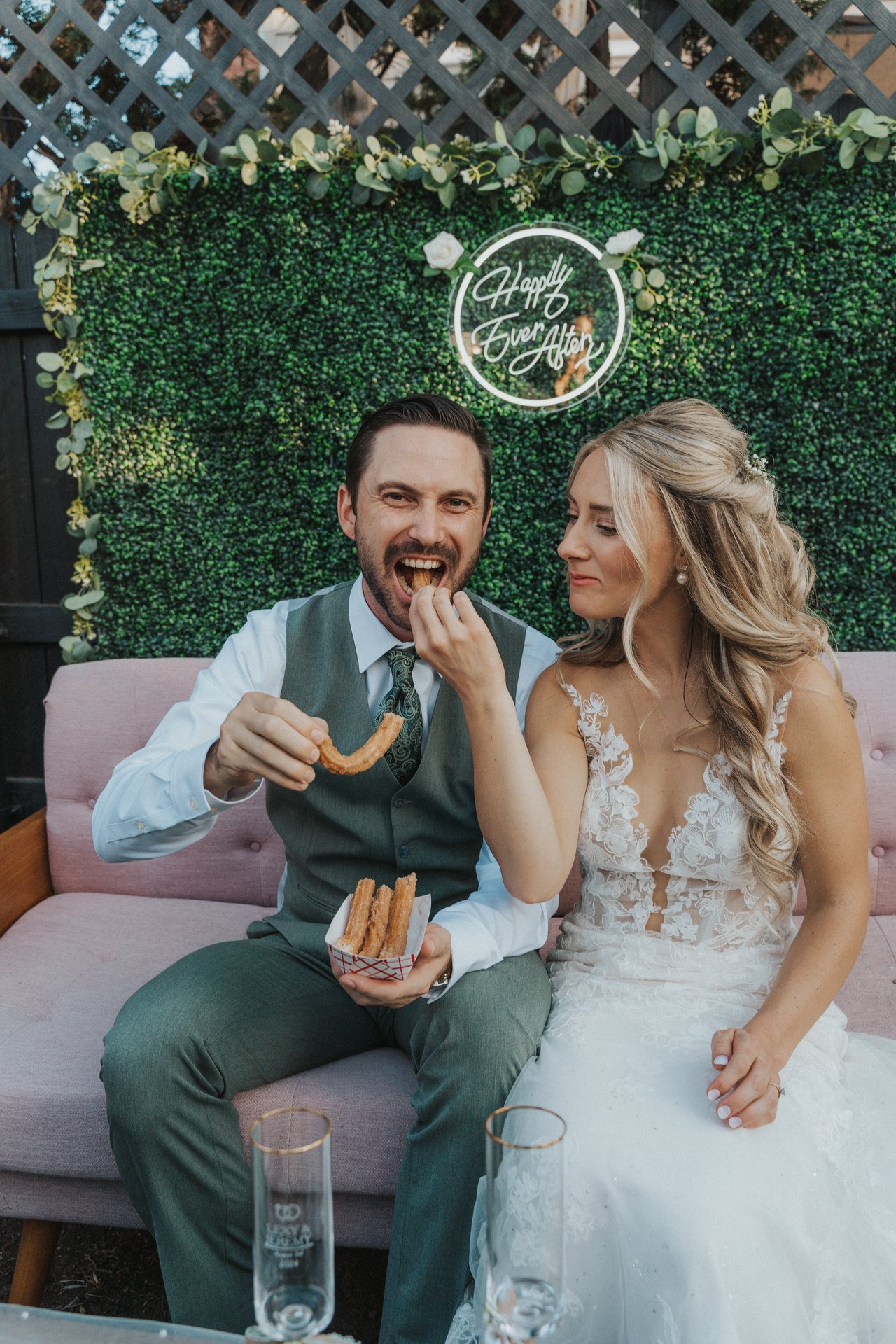 Jeremy laughs as he takes a bite of a churro on the couch