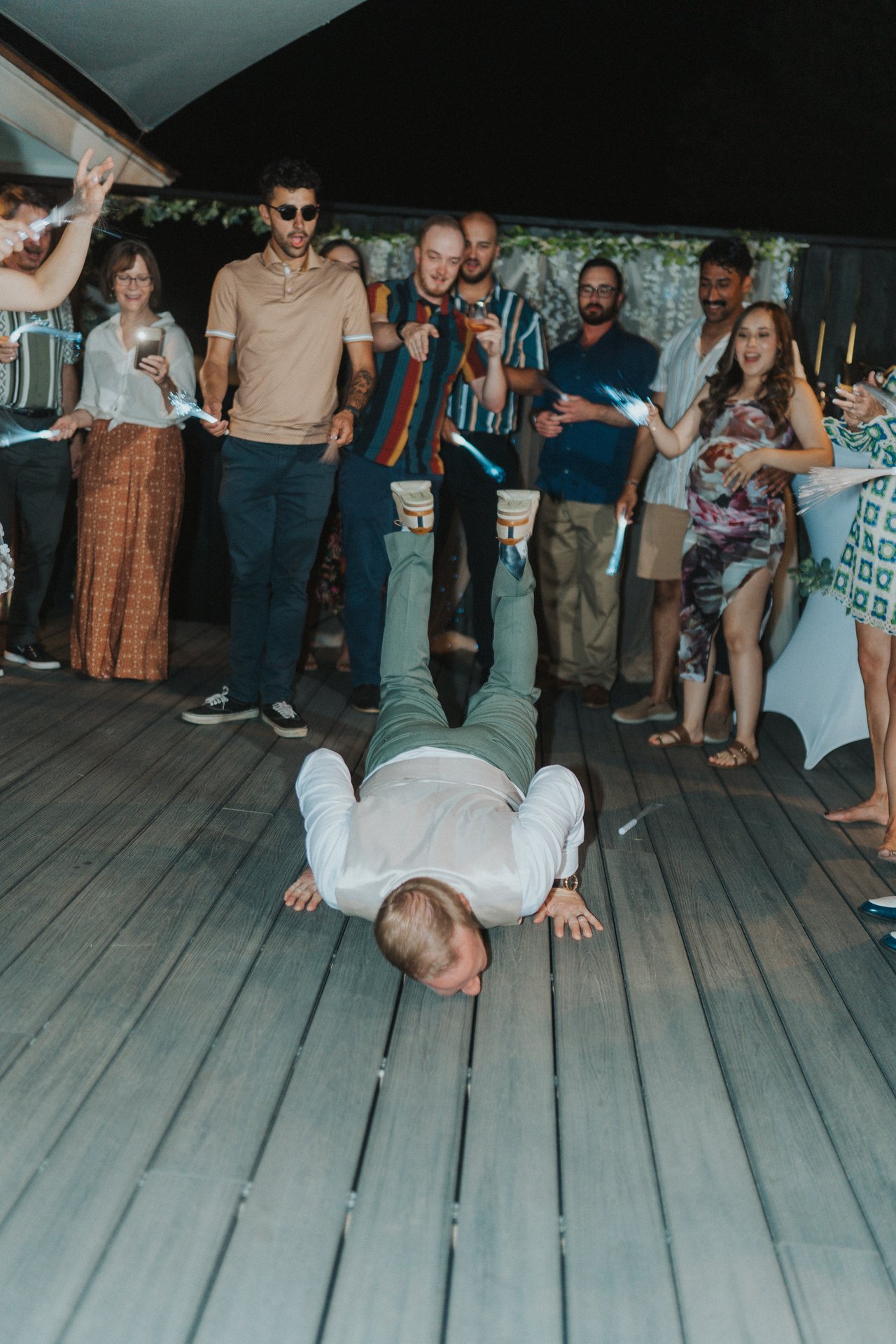 Friends cheer as a guest does the worm