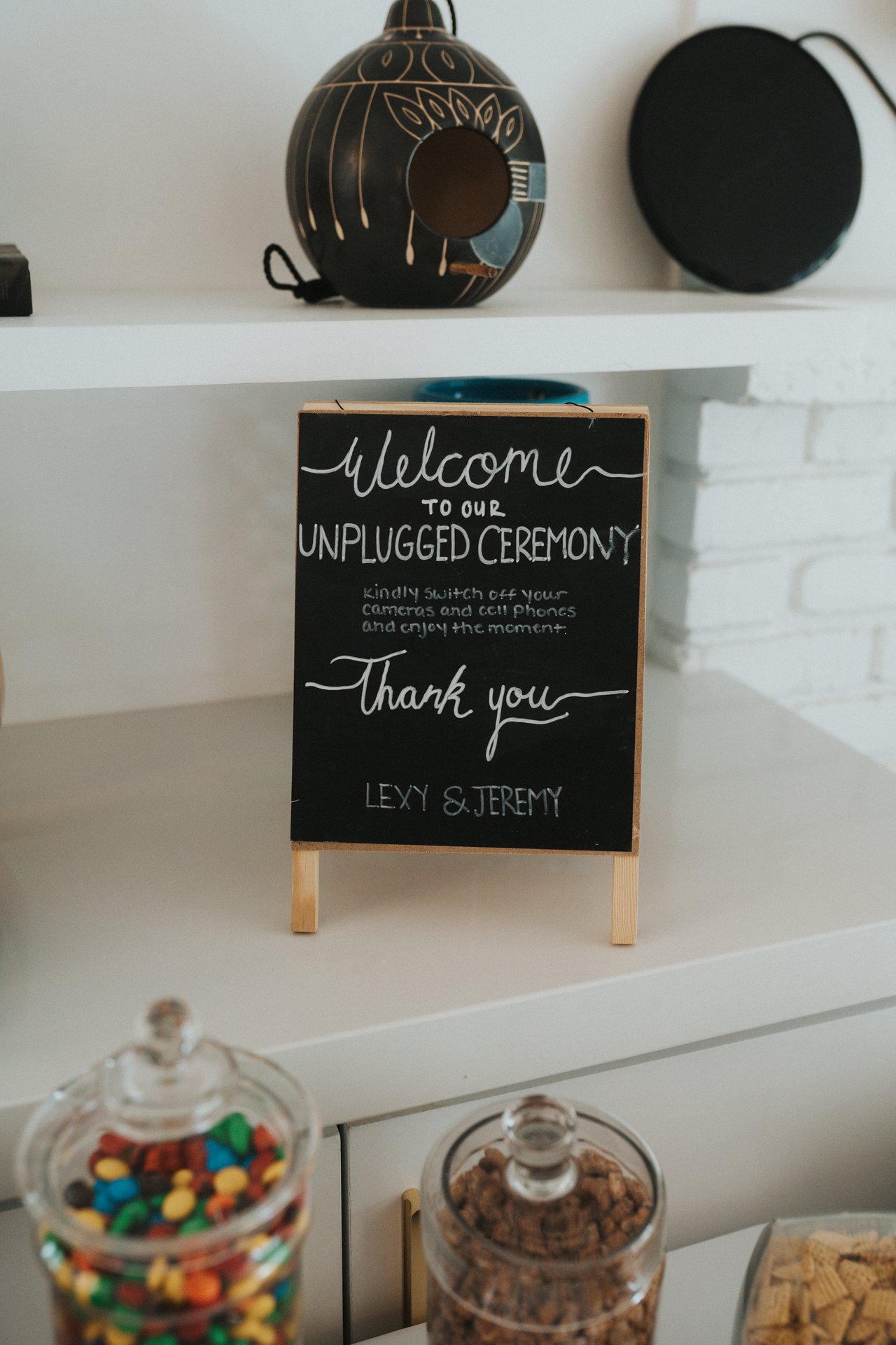 A chalkboard sign welcoming guests to an unplugged ceremony