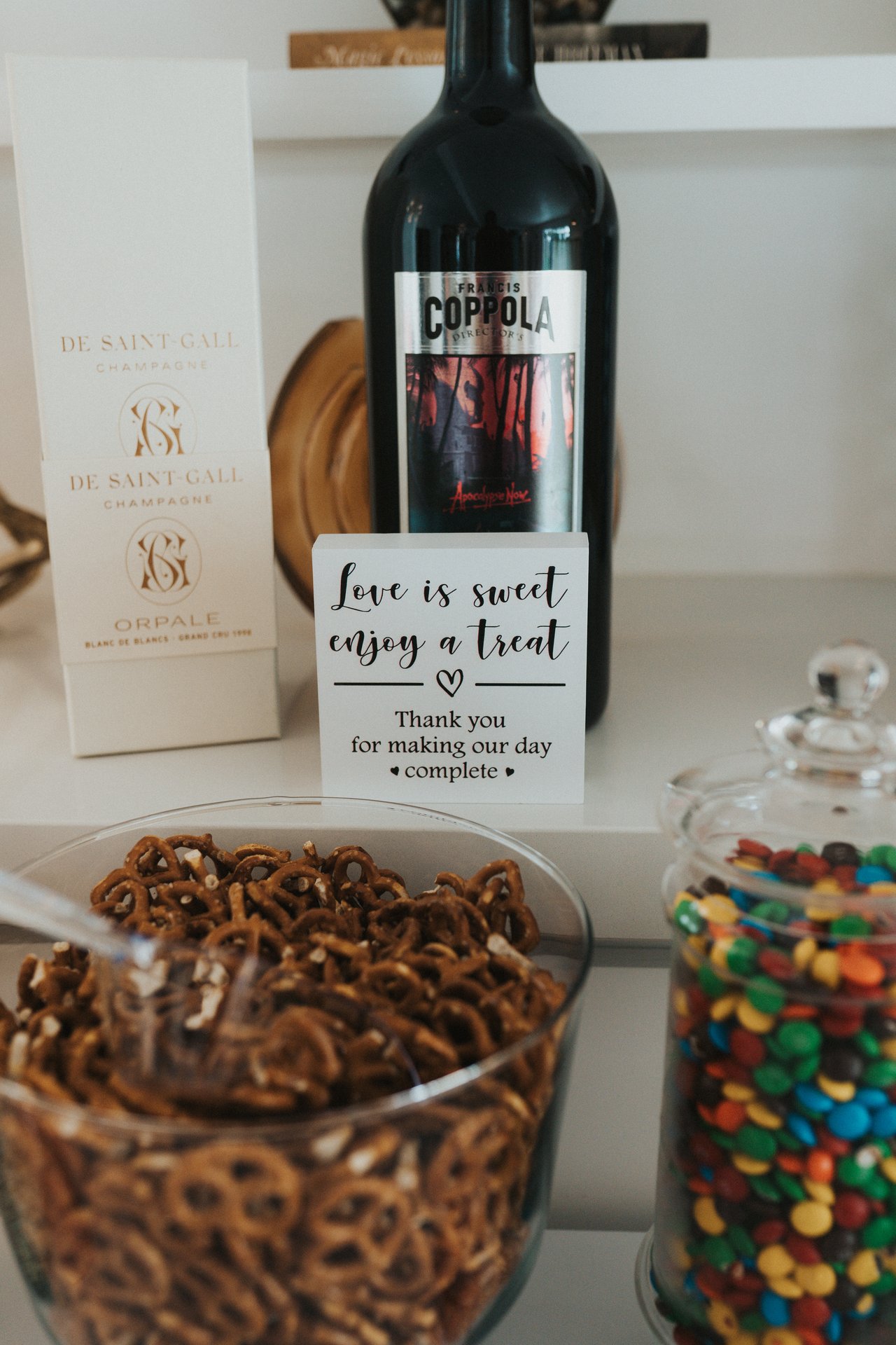 A bottle of wine and jars of treats on the candy bar