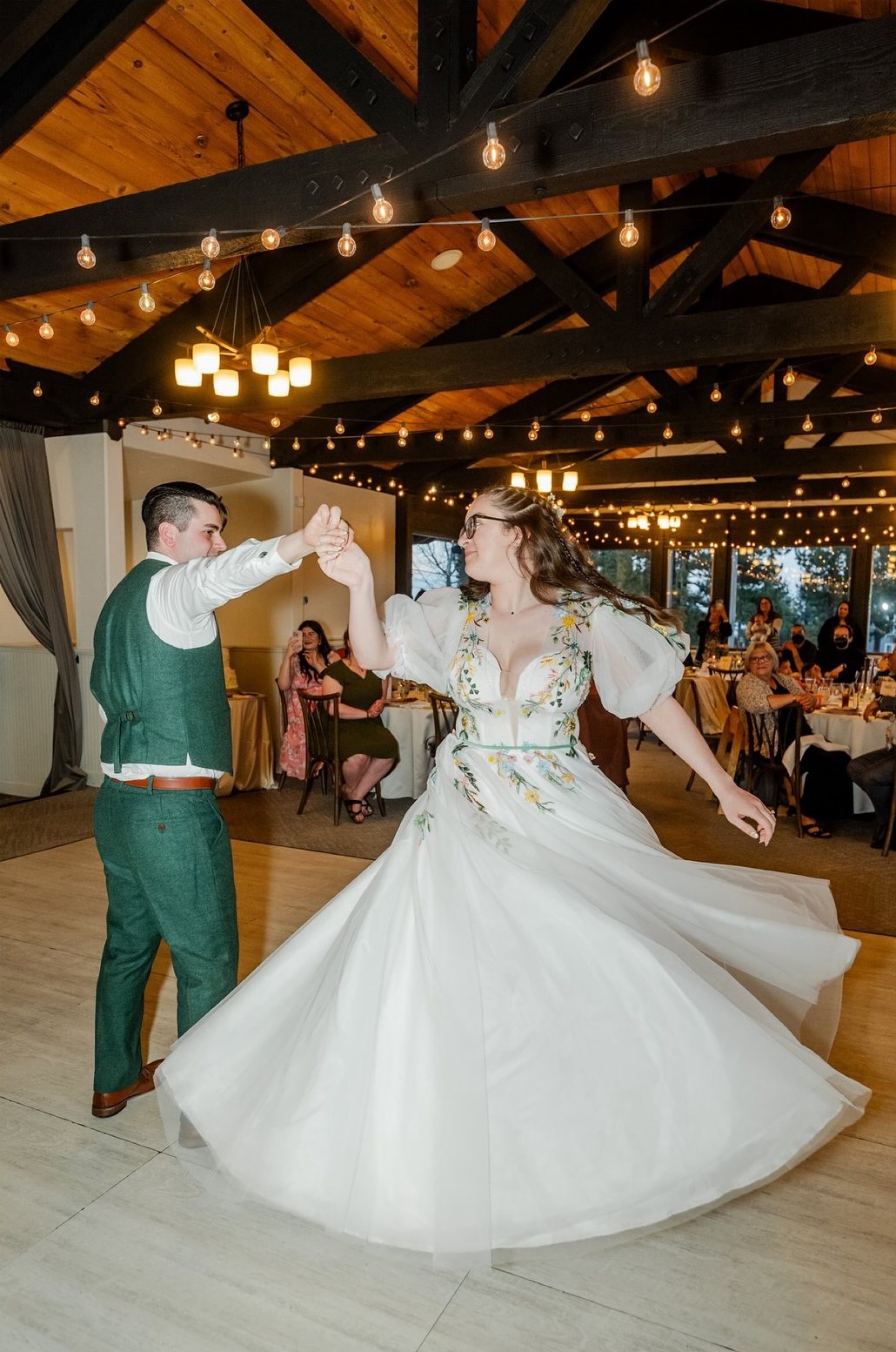 Adam twirls Madison on the dance floor under the wood beam ceiling