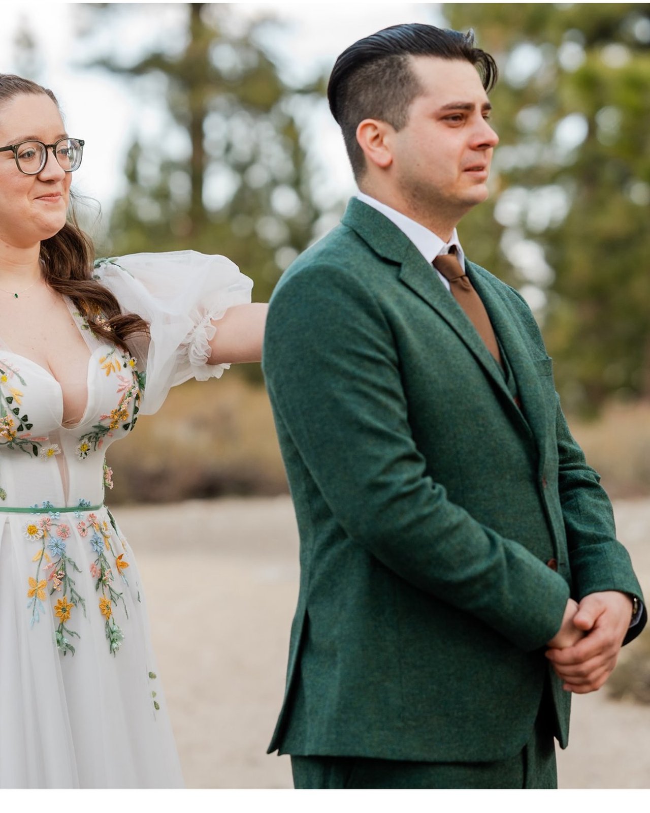 Madison reaches for Adam's shoulder at their first look as he waits in his green suit, tears in his eyes