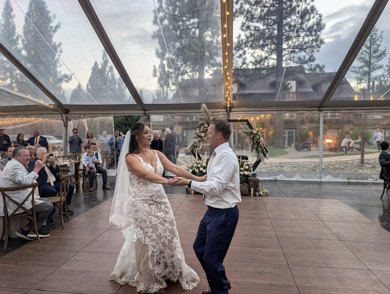 Molly and Matt share their first dance in the clear tent as guests watch from their tables