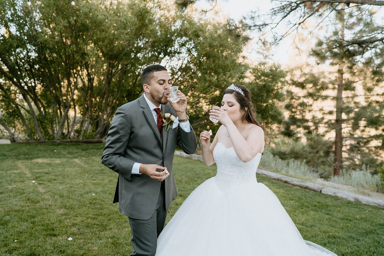 Montse and Jason toast each other with champagne on the lawn