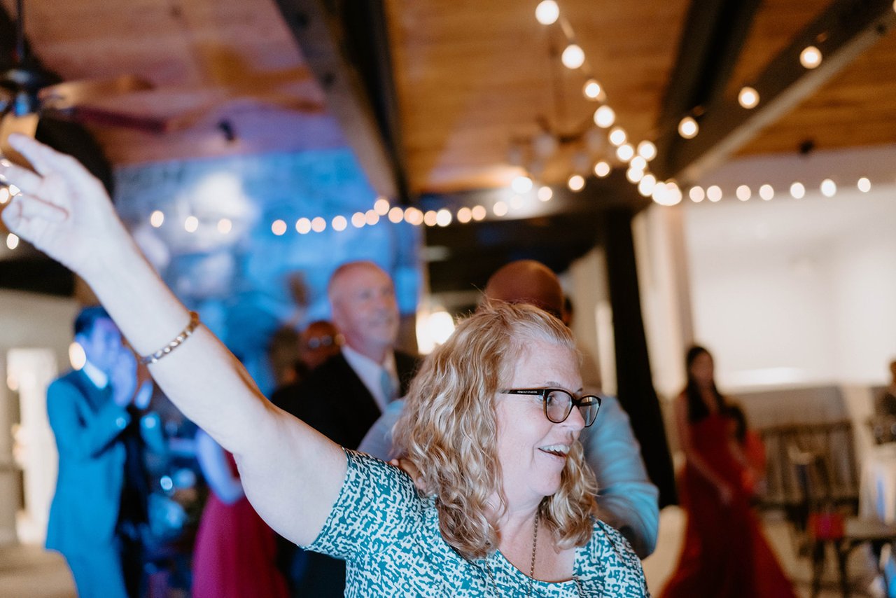 A guest throws her arm up on the dance floor