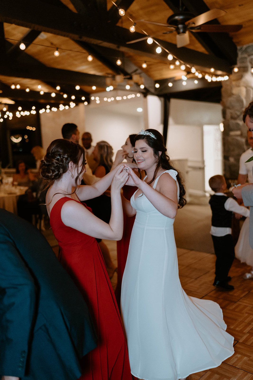 Montse dances with a bridesmaid in red during the dollar dance