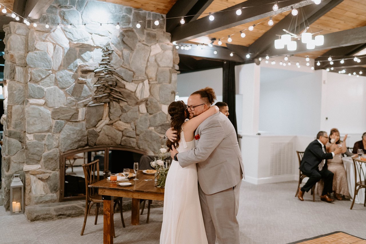 Montse hugs a guest by the fireplace after a toast