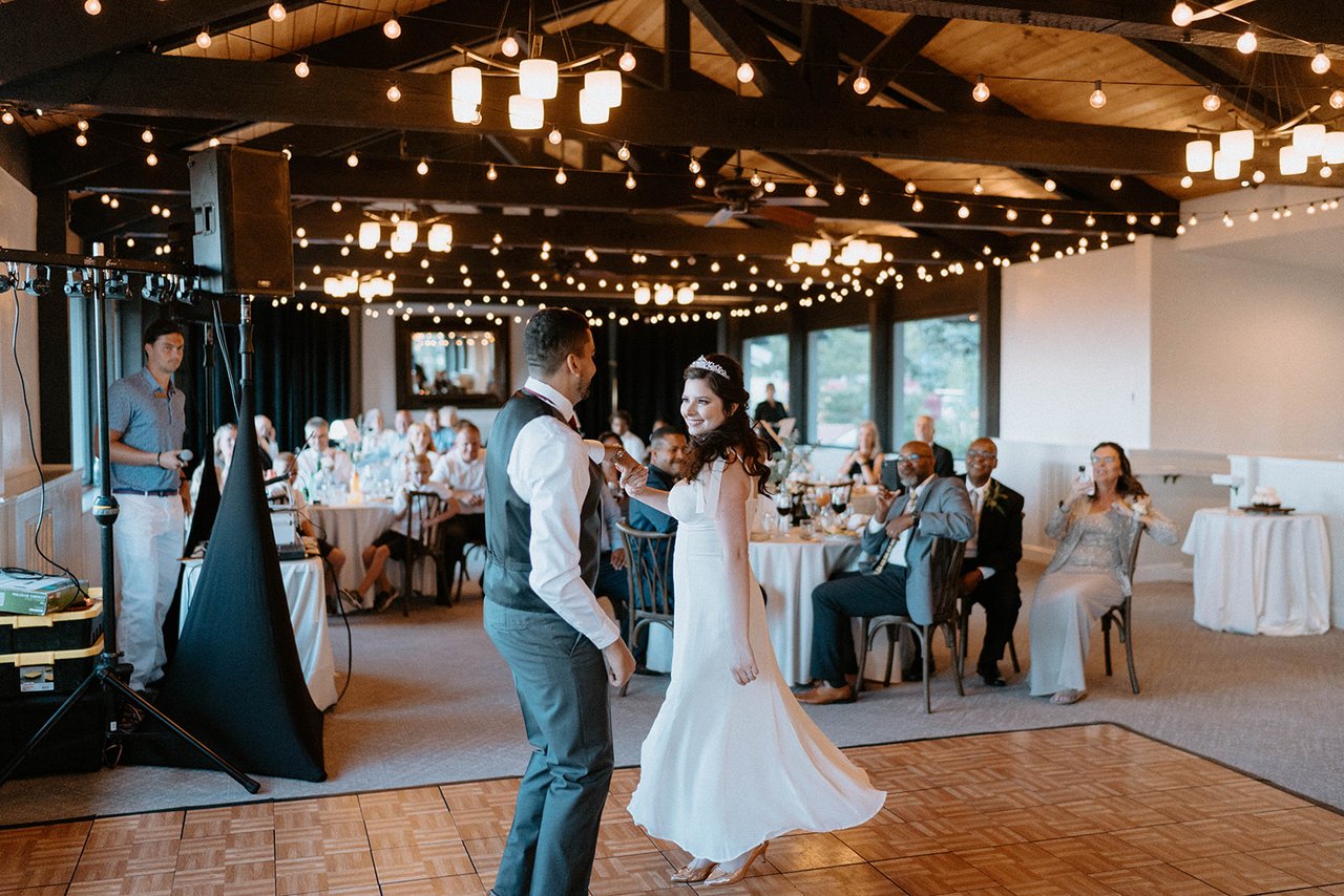 Jason twirls Montse under the string lights