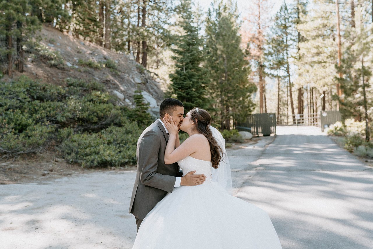 Montse and Jason kiss on the road through the pines