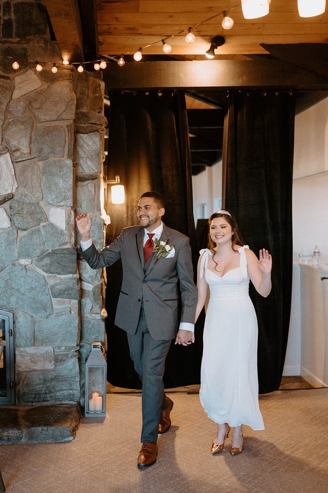 Montse and Jason wave as they walk into the reception