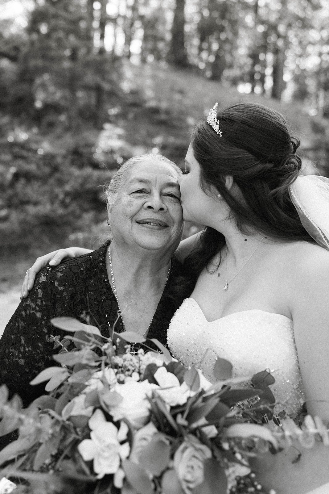 Montse kisses a loved one on the cheek, in black and white
