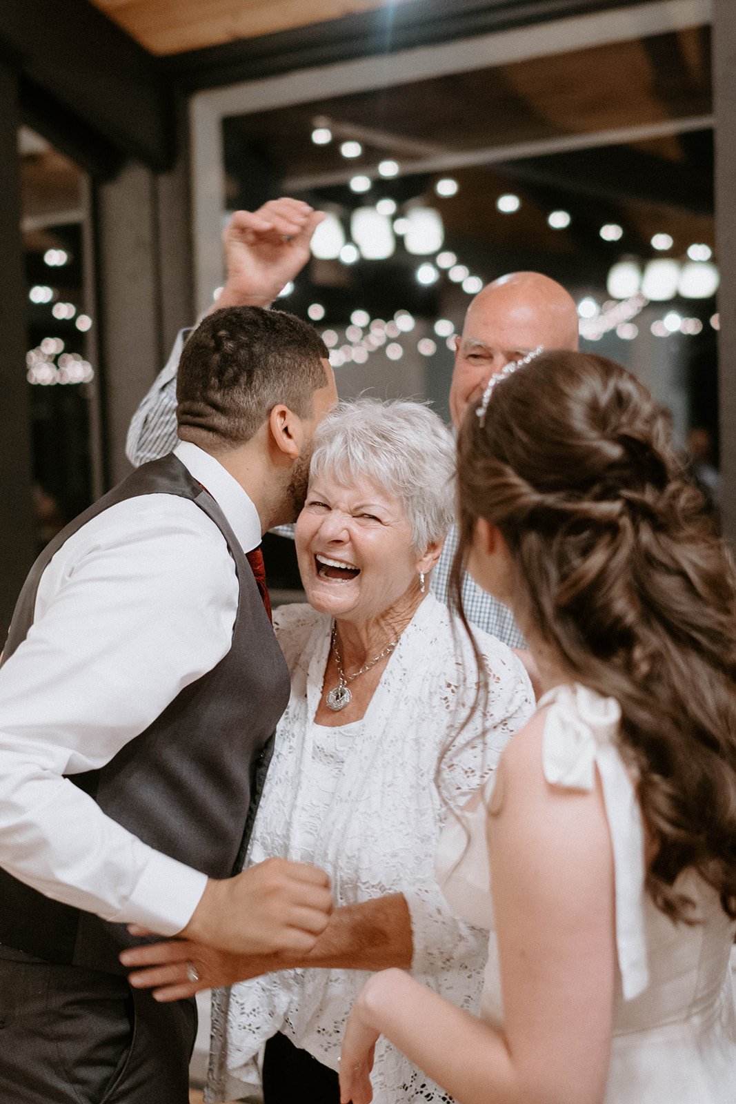 An older guest laughs with Jason and Montse on the dance floor
