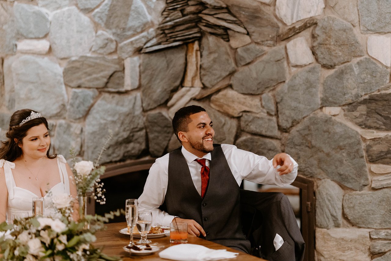 Jason laughs at a toast at the sweetheart table