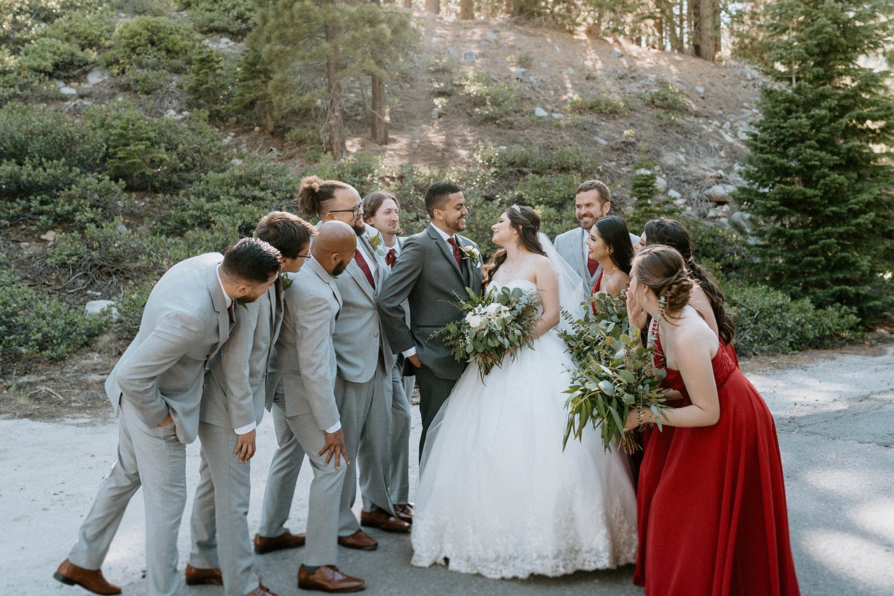 The groomsmen lean in toward Jason as Montse laughs