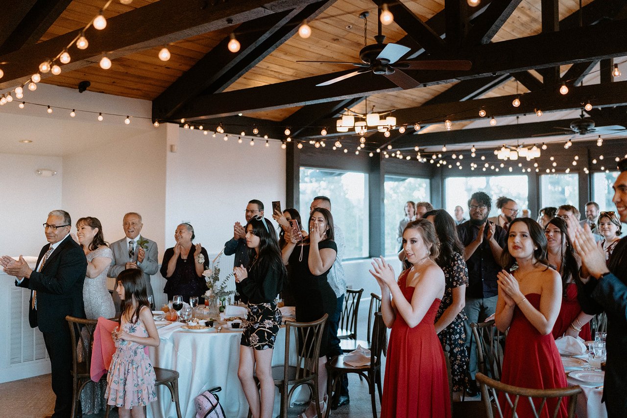 Guests stand and clap as Montse and Jason come in