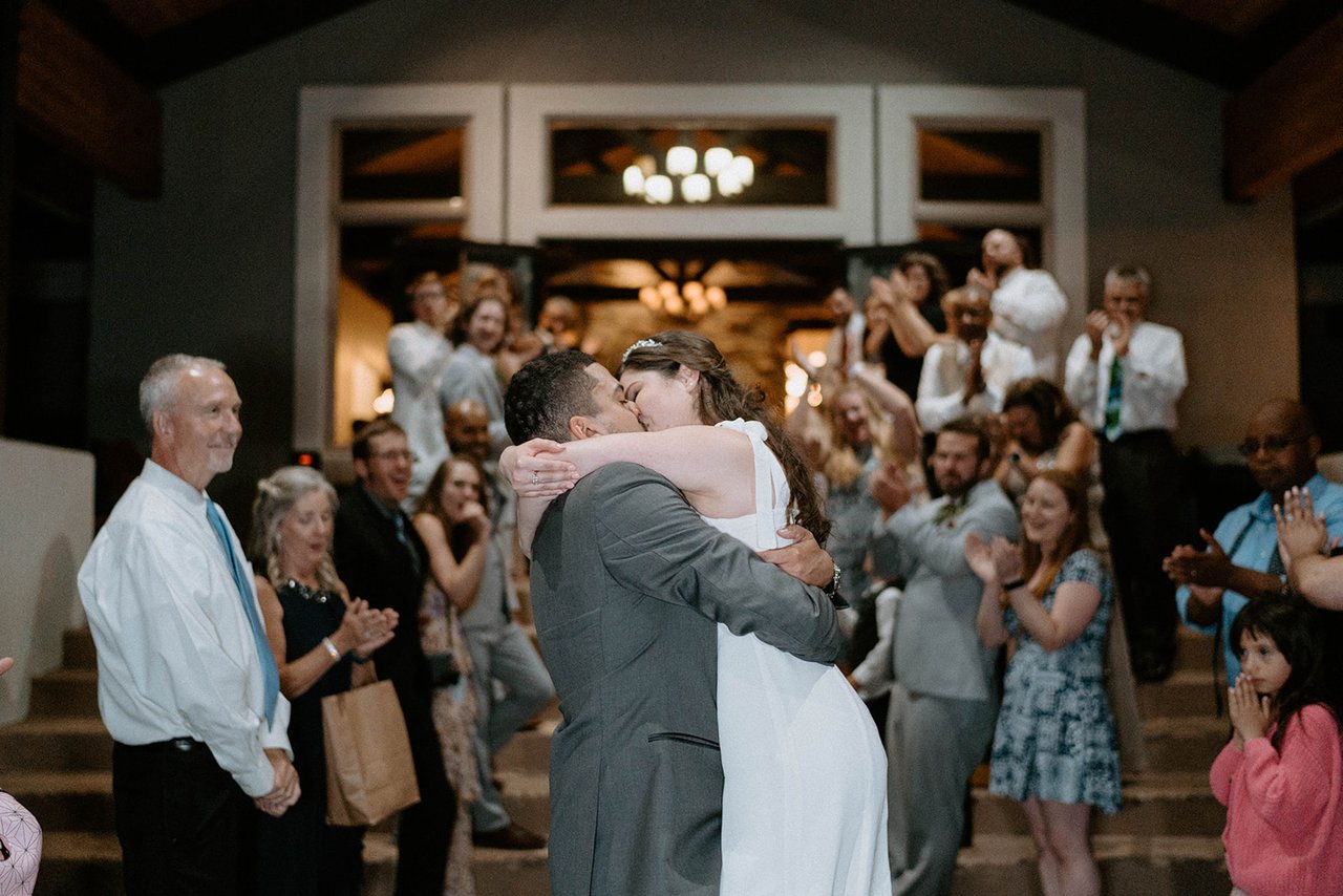 Jason lifts Montse into a kiss as guests cheer at the send off