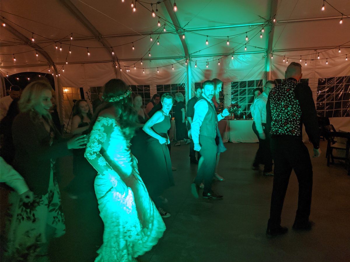The bride dances in the middle of the floor under green uplighting at Rachel and Christopher's Carson City reception
