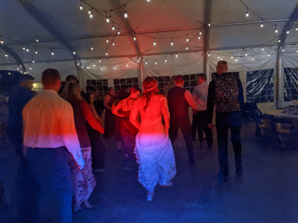 A packed dance floor bathed in deep red light at Rachel and Christopher's wedding