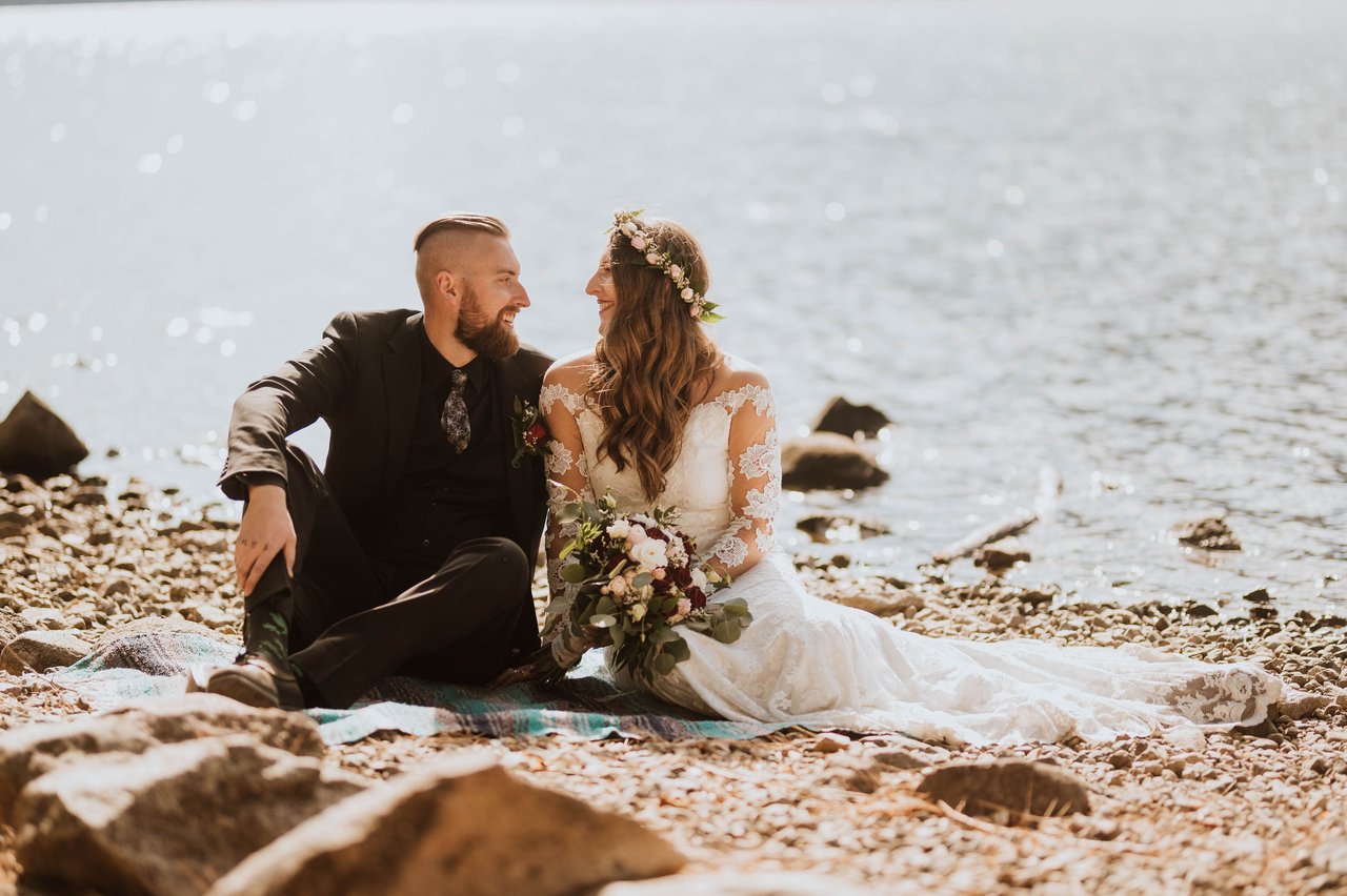 Rachel and Christopher sit together on the lakeshore