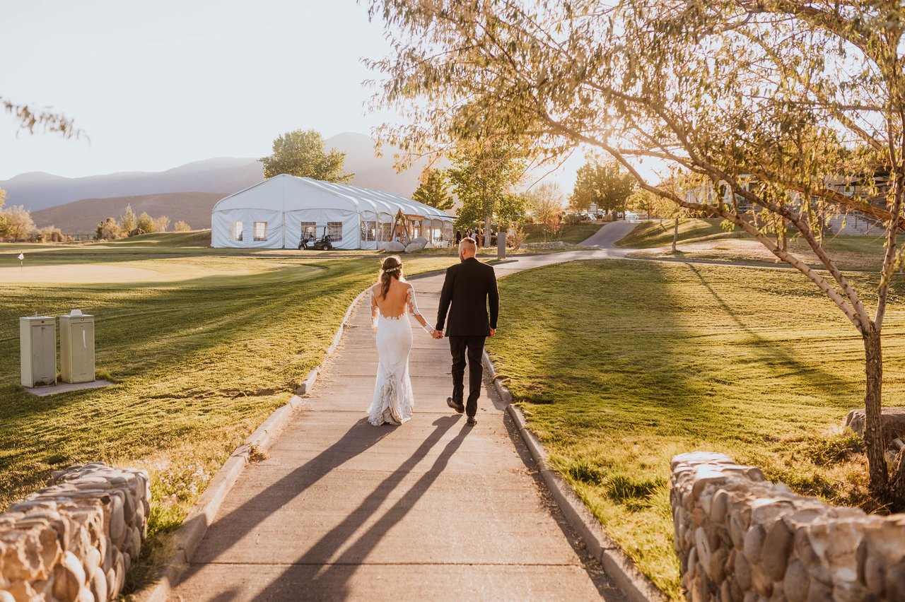 Rachel and Christopher walk toward the reception tent at Sunridge Golf and Recreation
