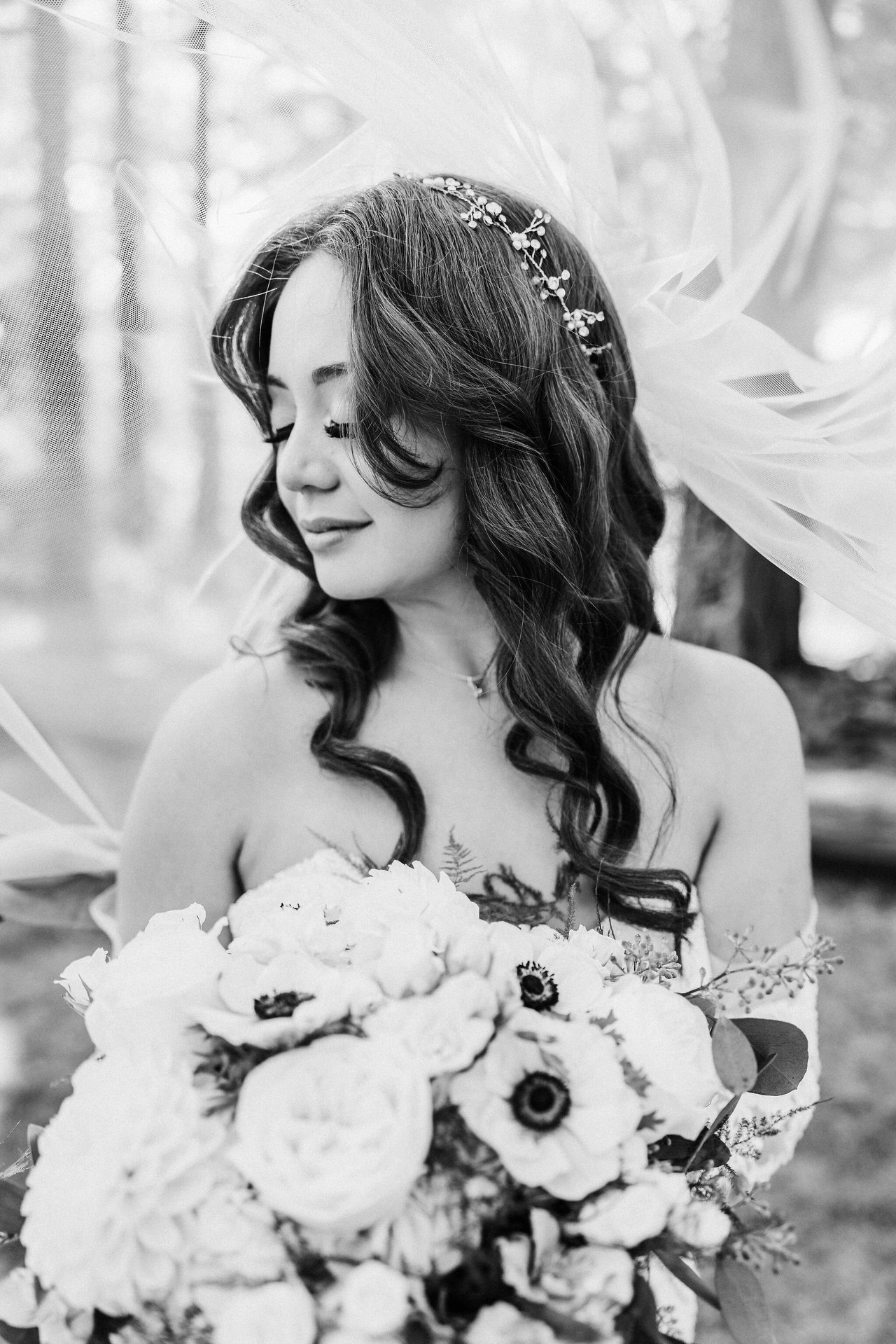 A black and white portrait of Remy in her gown and veil, holding her bouquet