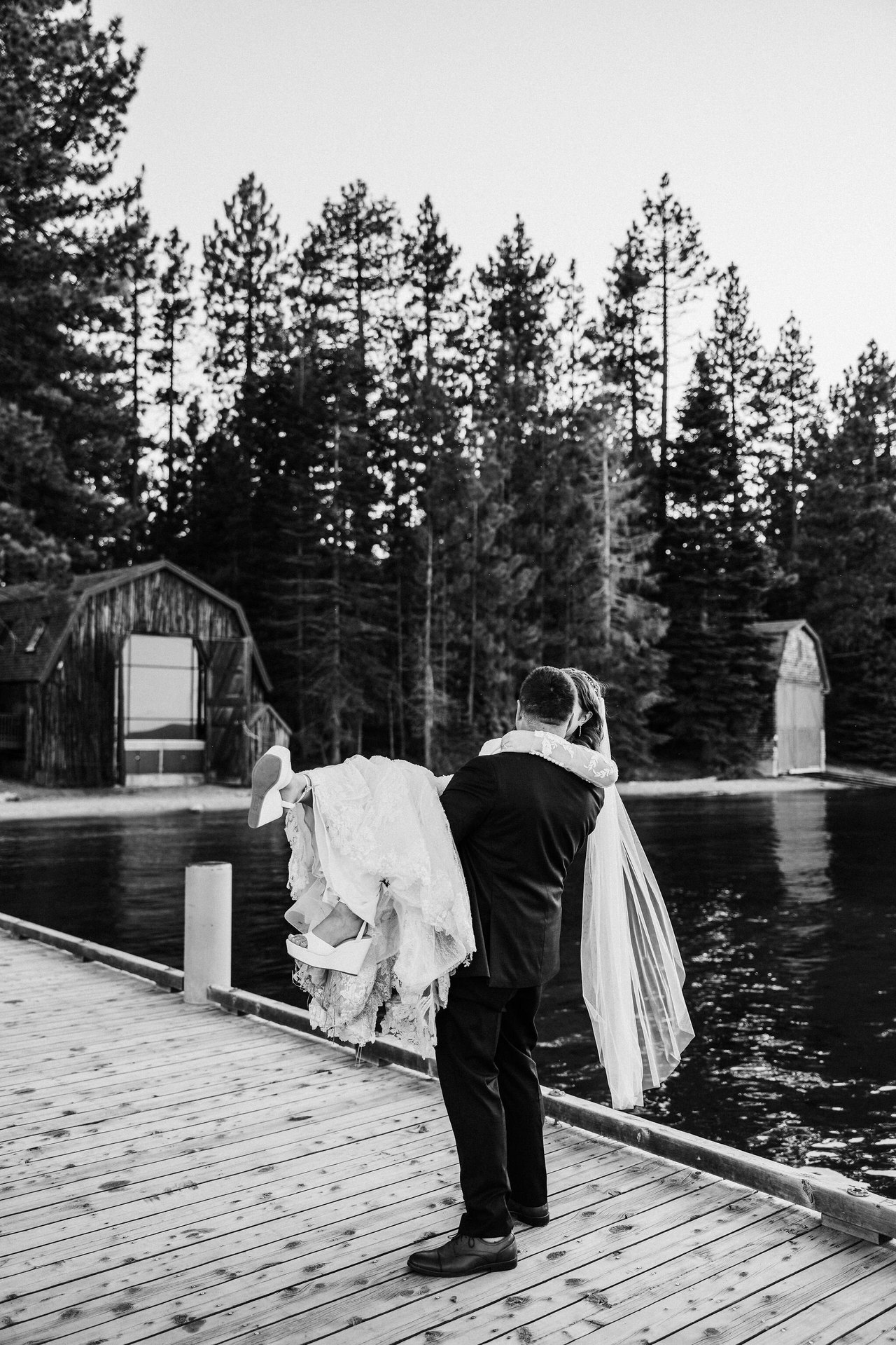 A black and white photo of Tom carrying Remy along the dock