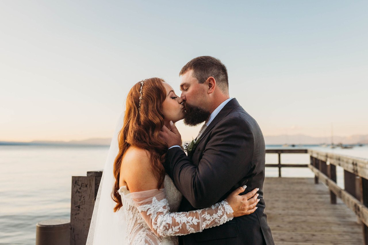 Remy and Tom kiss at the end of the pier as the sun sets over Lake Tahoe