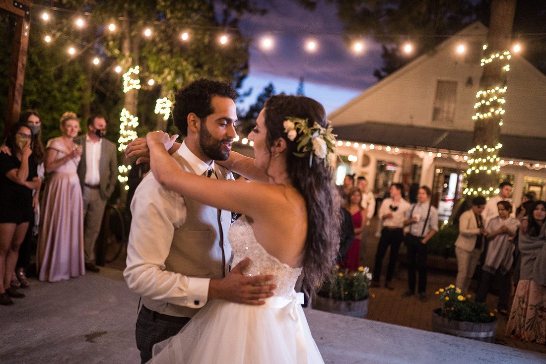 Shannon and Ryan share their first dance under the string lights as guests watch
