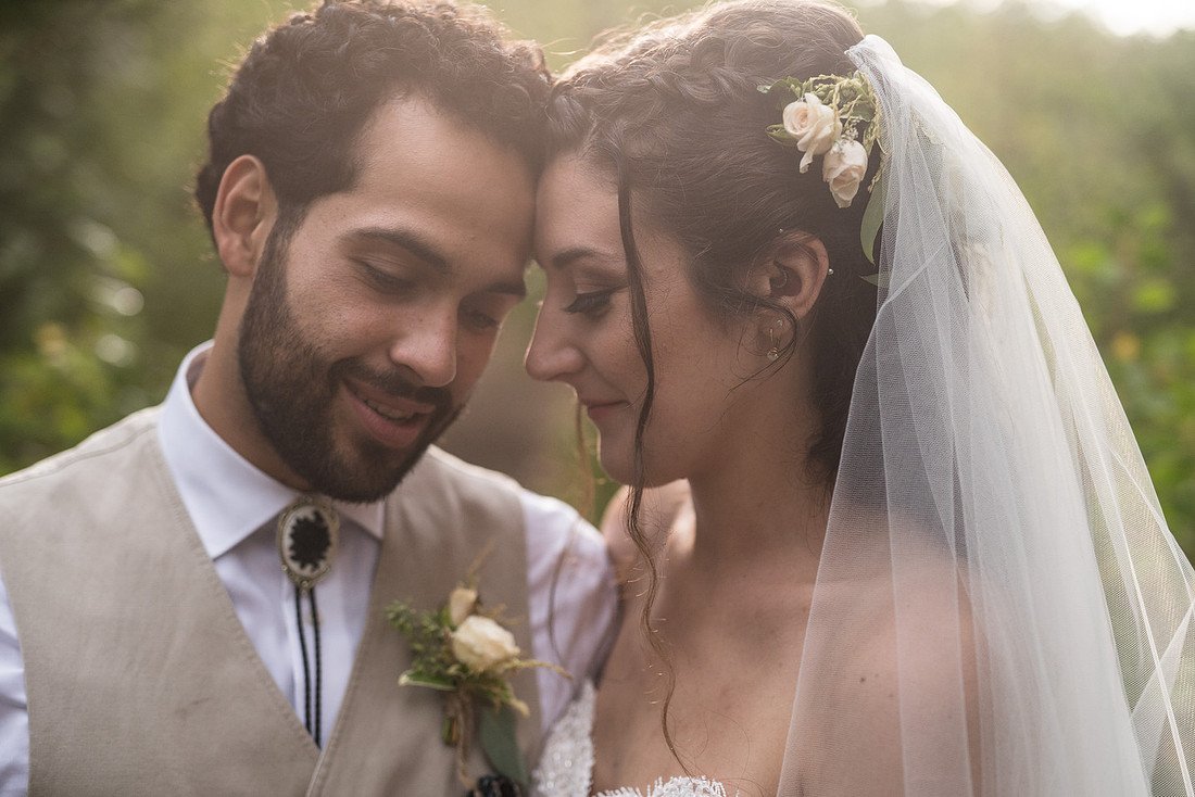 Shannon and Ryan touch foreheads in the golden light, her veil over her shoulder