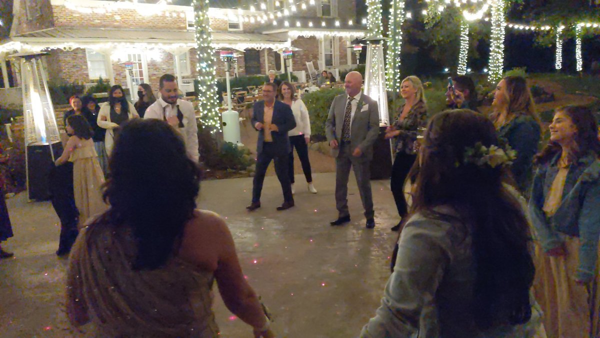 Rob dances in the middle of a circle of family and friends on the dance floor at Twenty Mile House