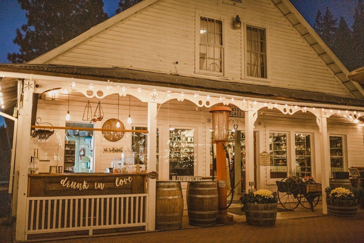 The General Store porch at dusk with a drunk in love bar sign and wine barrels, photo by Composing Reality Photography