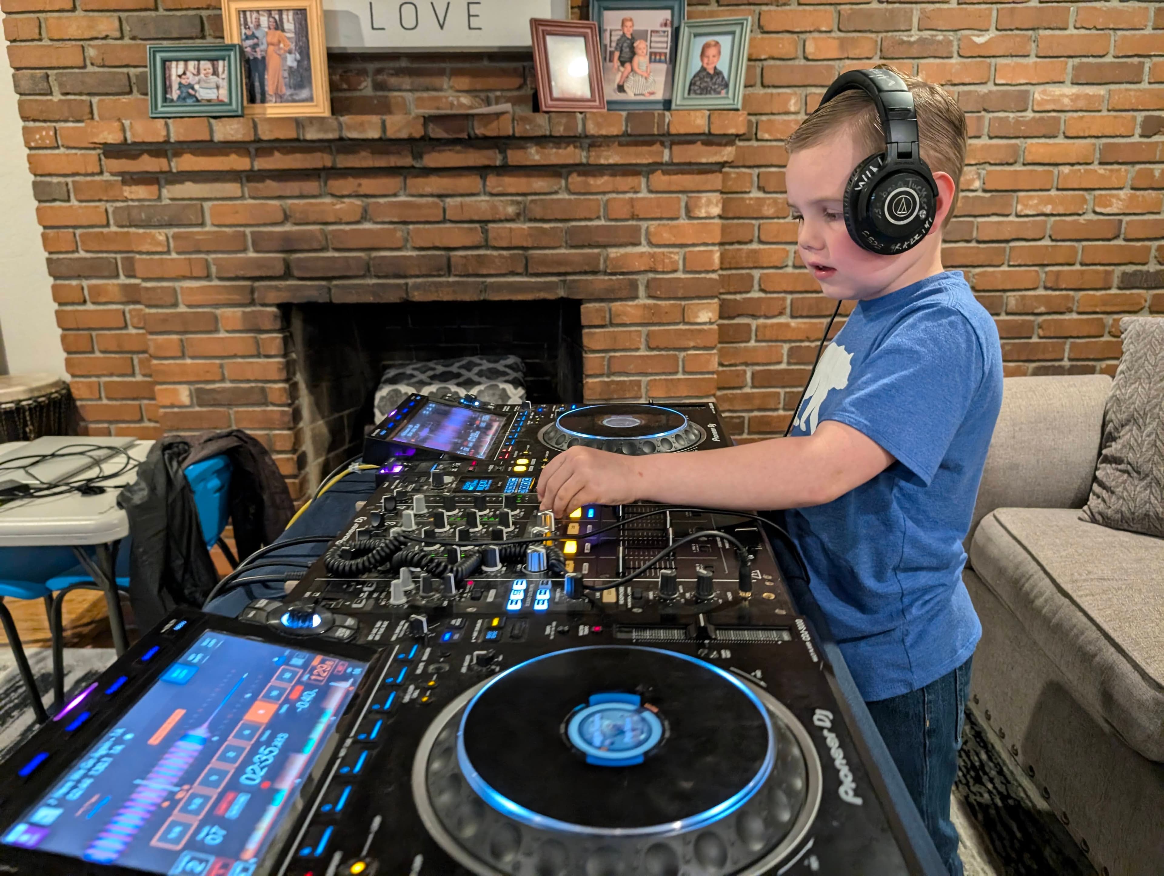 Young DJ student Deacan mixing on Pioneer DJ decks at home, wearing headphones